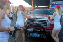 Участников ралли 'Шелковый путь' развлекают девушки, которые моют машины